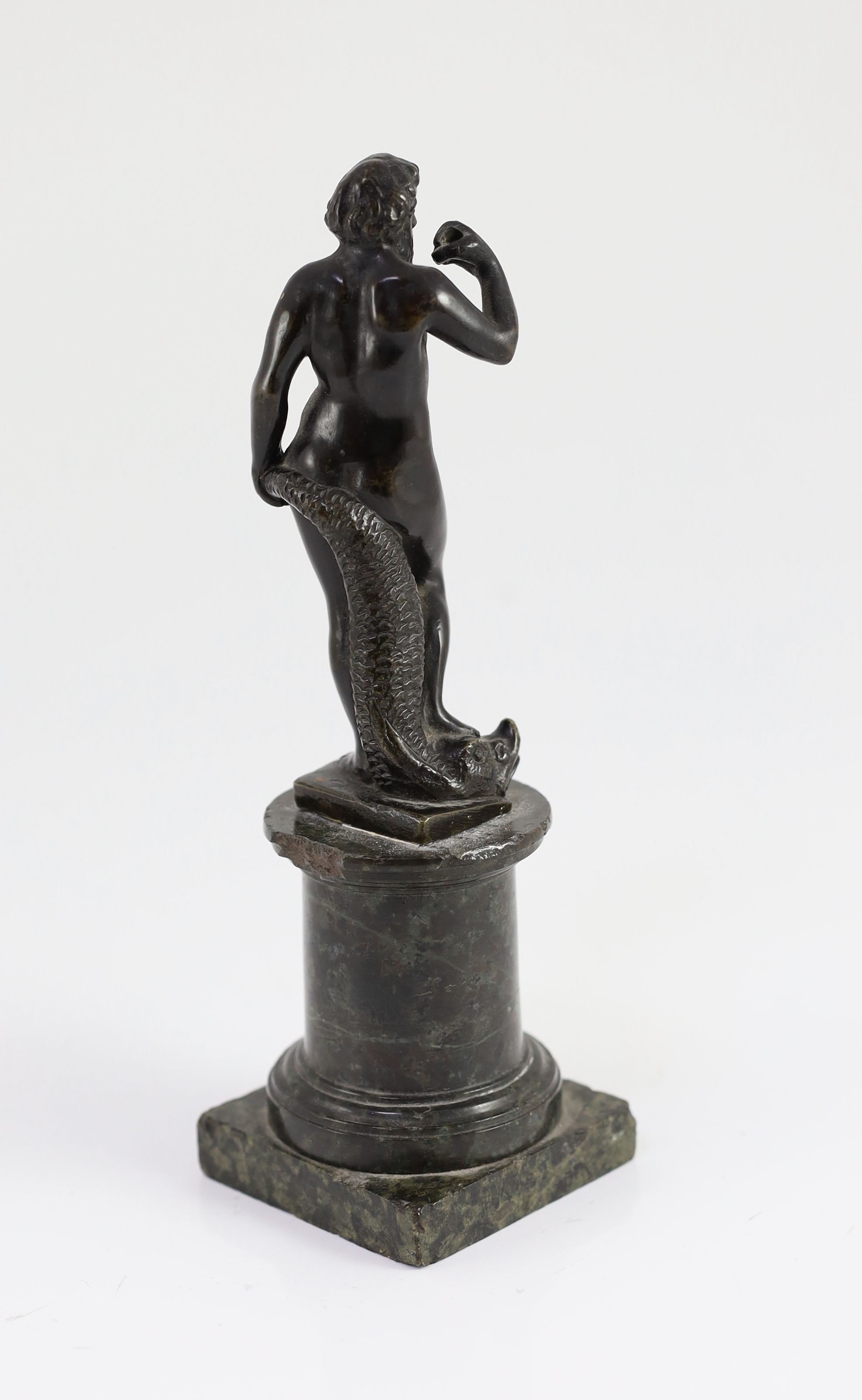 A small Roman bronze figure of Neptune standing with his foot upon a dolphin, overall height 21cm